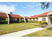 Neatly landscaped condo building with Spanish tile roofs and a walkway at 1430 57Th W St # 1430, Bradenton, FL 34209