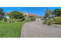 House exterior featuring a paved driveway, manicured lawn, and lush landscaping at 146 Willow Bend Way, Osprey, FL 34229