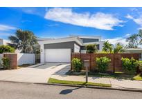 Modern home with attached two-car garage, landscaped yard, and wooden privacy fence at 2254 Hawthorne St, Sarasota, FL 34239