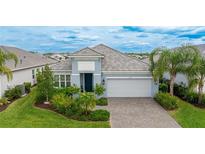 Beautiful home with gray roof and landscaping at 2582 Wild Cherry Path, Sarasota, FL 34240