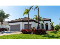 Single-story home with a two-car garage, landscaping, and a tile roof at 413 Wildlife Gln, Bradenton, FL 34209