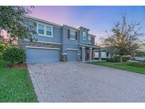 Charming two-story home with a three-car garage, brick driveway, stone accents, and well-maintained landscaping at 5001 65Th E Ter, Ellenton, FL 34222