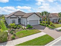 One-story home with tile roof, gray siding, and a paved driveway at 5361 Salcano St, Sarasota, FL 34238