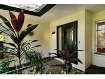 Inviting front entrance with lush landscaping and a charming door at 6947 Woodwind Dr # 77, Sarasota, FL 34231