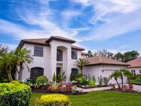 Two-story house with a white exterior, brown roof, and landscaped yard at 7724 Us Open Loop, Lakewood Ranch, FL 34202