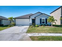 One-story home with gray siding, a two-car garage, and a well-manicured lawn at 8547 40Th E Cir, Palmetto, FL 34221