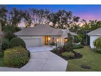 Charming single-story home featuring a tile roof, manicured landscaping, and an attached two-car garage at 1359 Tearose Pl, Sarasota, FL 34239