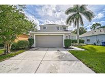 Charming two-story home featuring a well-manicured lawn and a spacious two-car garage at 1671 Mellon Way, Sarasota, FL 34232