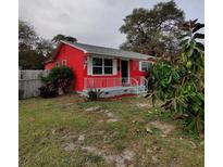 Charming one-story home with vibrant red exterior, quaint front porch, and well-maintained yard at 1711 41St S St, St Petersburg, FL 33711