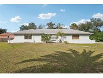 Charming single-story home with a well-maintained lawn and mature trees offering shade and curb appeal at 20313 Navajo Ln, Port Charlotte, FL 33952