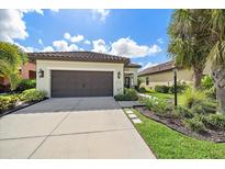 Single-story home with a two-car garage and landscaped front yard at 220 Alfero Way, Nokomis, FL 34275