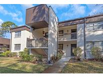 Condo exterior featuring well-maintained landscaping and an open-air stairwell to the second-story units at 2400 Winding Creek Blvd # 25-102, Clearwater, FL 33761