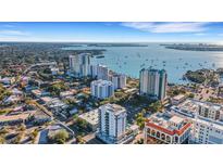 An aerial view of a coastal city featuring high-rise buildings, lush greenery, and stunning ocean views at 300 S Pineapple Ave # 802, Sarasota, FL 34236