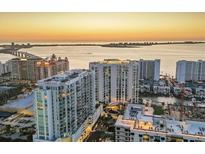 Stunning aerial view of luxury high-rise condos overlooking the ocean at sunset, showcasing prime waterfront real estate at 301 Quay Commons # 1411, Sarasota, FL 34236