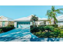 Charming single-story home featuring a blue garage door, well-manicured landscaping and a bright white facade at 308 Bermuda Ct # 13, Venice, FL 34293