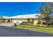 Bright yellow house with white roof, two-car garage, and well-manicured landscaping at 3749 Amesbury Ln # 5608, Sarasota, FL 34232