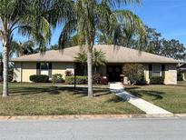 Single-story home with palm trees and landscaped yard at 5507 Country Lakes Trl, Sarasota, FL 34243