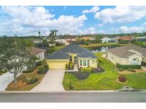 Aerial view of single-Gathering home with landscaped yard, driveway, and neighborhood pond at 5703 52Nd W Ave, Bradenton, FL 34210