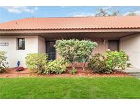 Front view of condo with attractive landscaping and red tile roof at 6666 Draw Ln # 132, Sarasota, FL 34238