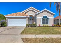 One-story house with tan walls, tile roof, and a two-car garage at 6978 Superior Street Cir, Sarasota, FL 34243