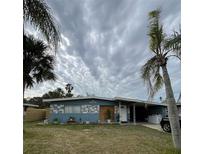 Ranch-style home with blue exterior, updated landscaping, and a spacious yard at 7309 Royal Palm Dr, New Port Richey, FL 34652