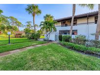 Exterior view of condo building with lush landscaping and walkway at 3500 El Conquistador Pkwy # 252, Bradenton, FL 34210