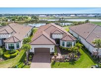 Aerial view of a single-story home with a tile roof, well-maintained lawn, and mature landscaping at 3860 Santa Caterina Blvd, Bradenton, FL 34211