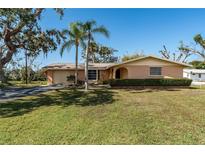 Charming single-story home with a manicured lawn and mature landscaping at 5630 Saint Louis Ave, Sarasota, FL 34233