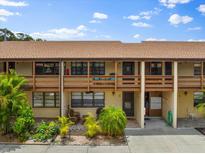 Front view of condo building with balconies, landscaping, and parking at 7 Quails Run Blvd # 9, Englewood, FL 34223