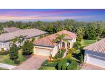 Stunning single-story home with tile roof, lush landscaping, and brick driveway at 7103 Westhill Ct, Lakewood Ranch, FL 34202