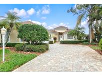 Beautiful home exterior featuring a well-manicured lawn and a brick driveway at 7327 Kensington Ct, University Park, FL 34201