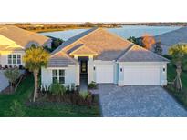 Two-story home with light blue exterior, white garage doors, and landscaping at 8063 Waterbend Trl, Sarasota, FL 34240