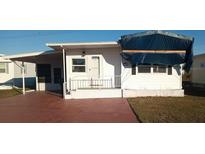 White single-wide manufactured home with carport and covered walkway at 1863 Palm Springs St, Sarasota, FL 34234