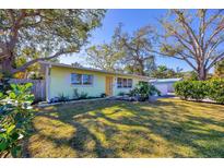 Light green house with a yellow door, surrounded by lush landscaping at 2040 Palm Ter, Sarasota, FL 34231