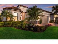 Beautiful single-Gathering home showcasing lush landscaping, a tile roof, and an attached two-car garage at 3023 Vittorio Ct, Lakewood Ranch, FL 34211