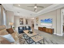 Bright, open living room with a view to the kitchen and dining area with modern decor at 3105 Formia Ct, Bradenton, FL 34211