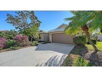 Charming home with a well-maintained lawn, colorful flowers, and a two-car garage at 5116 Timber Chase Way, Sarasota, FL 34238