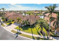 Stunning Mediterranean-style home featuring a tile roof, lush landscaping, and a circular driveway with mature palm trees at 5155 Cantabria Crest, Sarasota, FL 34238