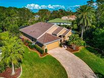 Beautifully landscaped home with brick paved driveway, mature palm trees, and tile roof at 779 Fordingbridge Way, Osprey, FL 34229