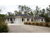 Charming single-story home with a gravel driveway and attached one-car garage at 8570 Tropicaire Blvd, North Port, FL 34291