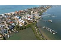 Aerial view of waterfront condo community with tennis courts and pool at 8767 Midnight Pass Rd # 505F, Sarasota, FL 34242