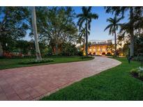 Grand estate entrance with brick driveway and palm trees at 1067 Westway Dr, Sarasota, FL 34236
