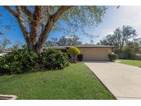 Charming single-story home with a well-manicured lawn and mature landscaping at 1208 Francis Ave, Sarasota, FL 34232