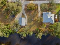 Aerial view of a charming home with a matching detached garage situated on a riverfront property at 27350 San Carlos Dr, Punta Gorda, FL 33983