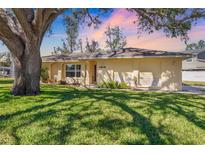 Charming single-story home with a well-manicured lawn and mature trees, bathed in warm sunset light at 4808 29Th W Ave, Bradenton, FL 34209
