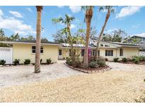 Charming home with a well-maintained exterior, tropical landscaping, and a gravel driveway at 5107 Saint Albans Ave, Sarasota, FL 34242