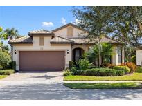 Single-story home with brown garage door and landscaped yard at 5639 Rain Lily Ct, Sarasota, FL 34238
