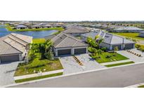 Aerial view of new homes with tile roofs and two-car garages, located near a lake at 5429 Mystic Water Cv, Bradenton, FL 34211