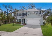 Charming two-story home with well-maintained lawn, a two car garage, and mature landscaping at 5809 71St E St, Palmetto, FL 34221