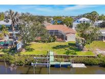 An aerial view of a home with a screened-in pool, green lawn, and dock on the water at 907 Garland Ave, Nokomis, FL 34275